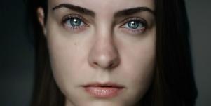 woman with dark hair staring directly at camera