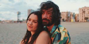 man and woman sitting on beach