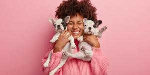 woman holding two puppies