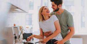 man embracing woman by the waist in kitchen