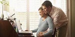 pregnant couple at computer