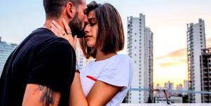 man kissing woman on forehead