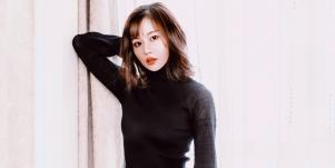 woman wearing black in front of white wall