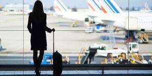 woman with luggage looking at airplanes