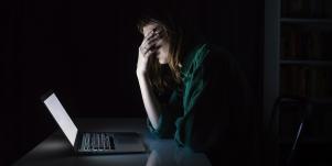 woman looking at computer in dark