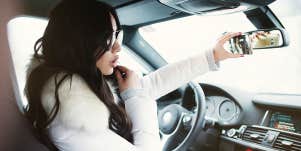 woman taking selfie in car