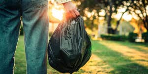 person taking trash bag out