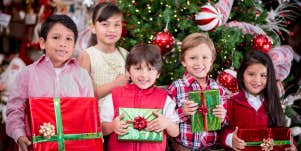 group of kids holding Christmas gifts