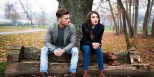 woman and man sitting on a bench angry at each other