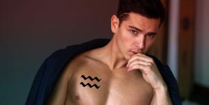 man with aquarius tattoo on chest