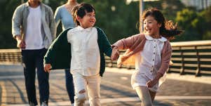 little boy and girl running and playing outside