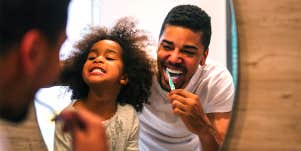 dad and daughter brushing teeth in morning