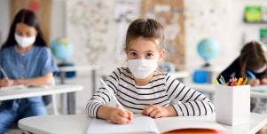 girl wearing mask in classroom