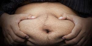 photo of man clutching his big belly