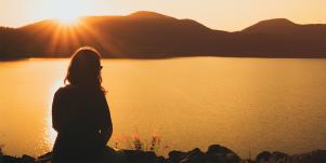 woman sitting in shadow looking at mountains