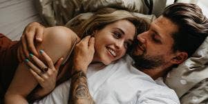 couple smiling hugging in bed