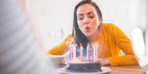 woman blowing out candles on a cake