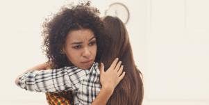unhappy woman hugging another woman
