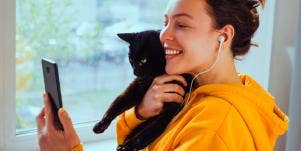 woman holding black cat