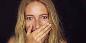 woman with hand over mouth