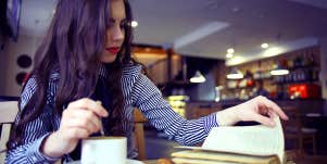woman at coffee shop reading book