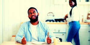 man rolling his eyes with back turned to woman in the background