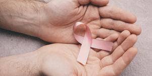 woman holding breast cancer pin