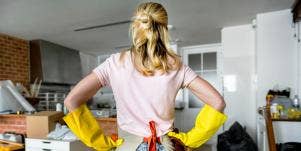 woman with hands on hips looking at messy house