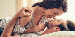 man and woman kissing in bed
