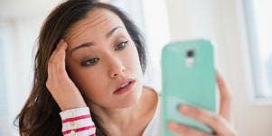 stressed-out woman looking at phone 