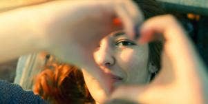woman forming a heart with her hands