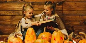 2 girls reading a book on halloween