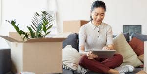 woman sitting with ipad and box with plant
