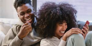 Couple laughing on couch
