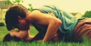 couple kissing in grass