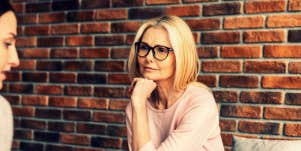 blonde therapist with glasses listens to client