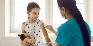 little girl getting a vaccine from a nurse