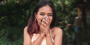 woman being flattered covering face