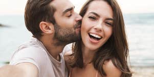 man kissing woman on cheek
