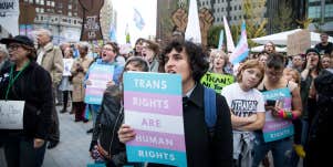 people gathered in trans protest against anti trans legislation, holding up signs