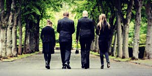 four people walking away from a funeral