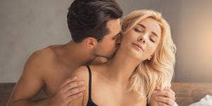 man kissing woman on neck