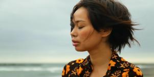 depressed woman on overcast beach 