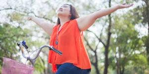 woman on a bike and stretching her arms