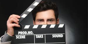 actor holding film clapper