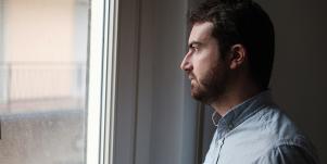 sad man looking out window