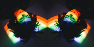 woman laying on floor with rainbow reflection on her face