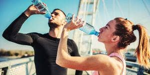 man and woman drinking water from bottles