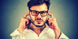 emotionally unavailable man with his fingers in his ears