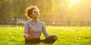woman meditating on the grass